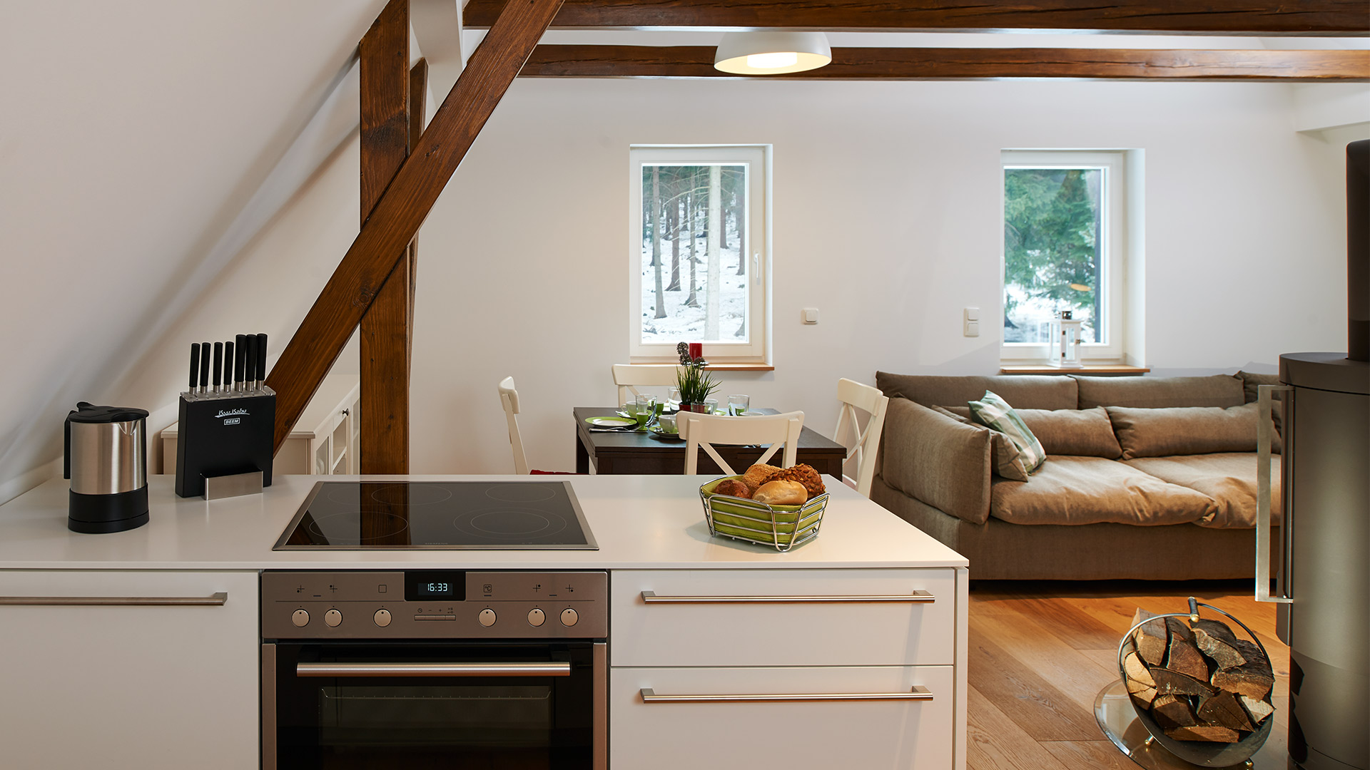 Die moderne Küche bietet einen schönen Kontrast zu den rustikalen Holzbalken im Obergeschoss.
