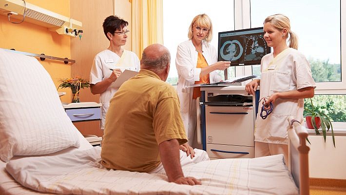 Anhand der Röntgenbilder bespricht die Ärztin die Diagnose mit dem Patienten.